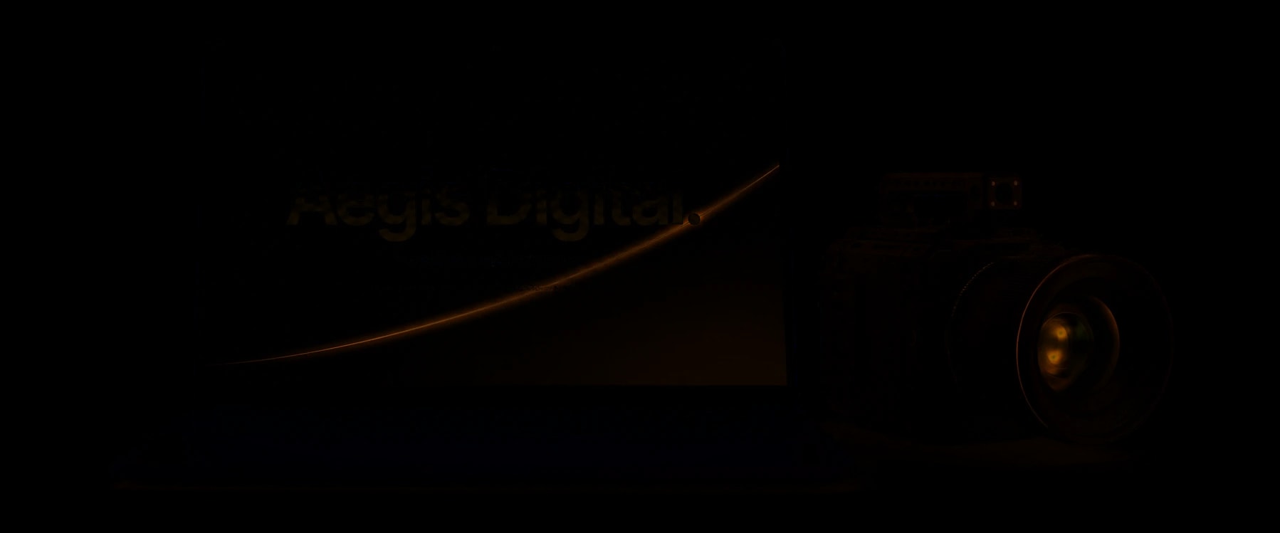 The Aegis Digital brand film on a laptop beside a cinema camera